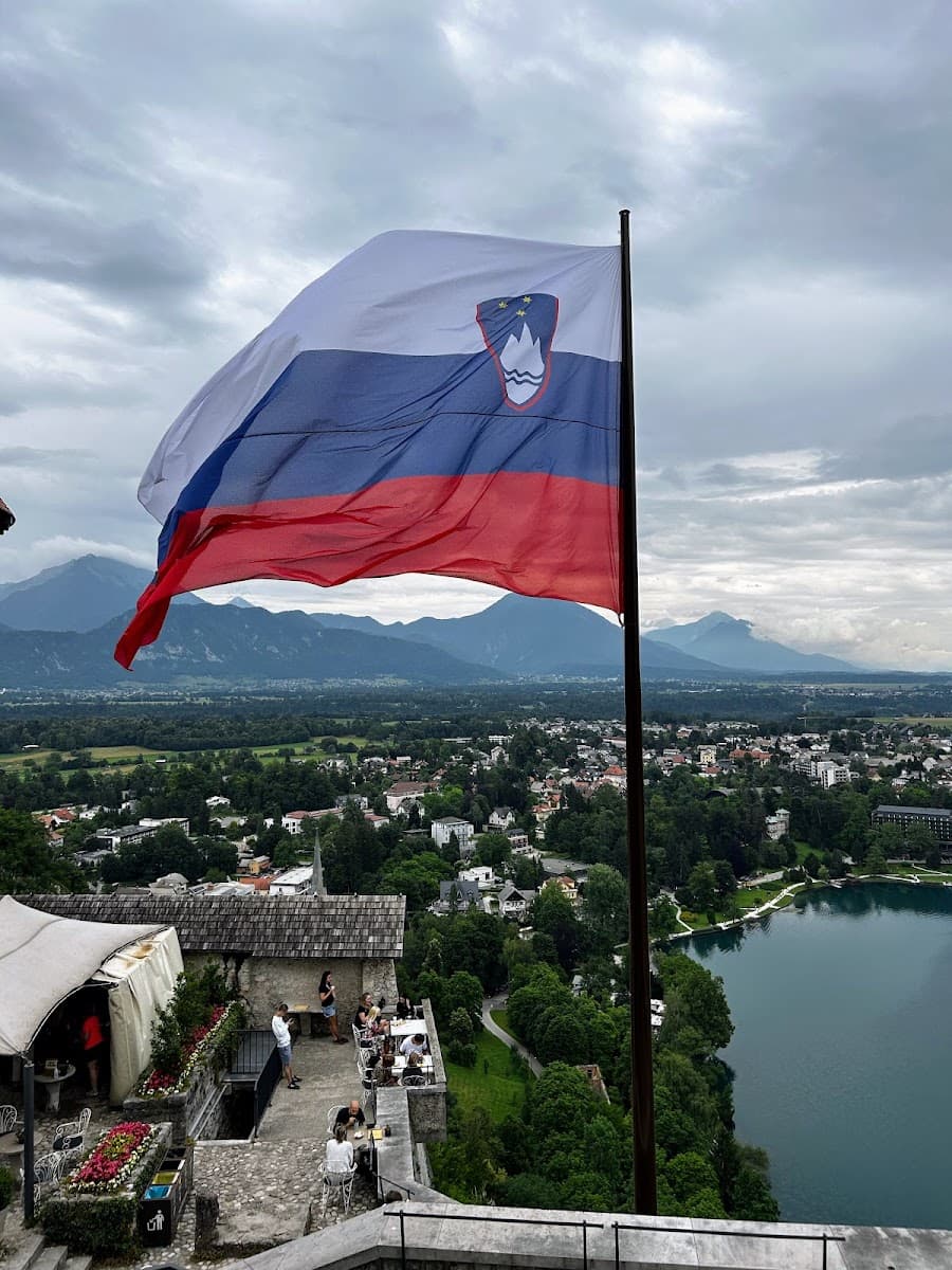 Slovenian flag flying over terrace dining with view of Lake Bled and mountains
